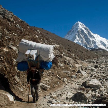 Sherpa im Himalaya mit schwerer Last, aus: Tourismus und Menschenrechte – egal oder nicht?