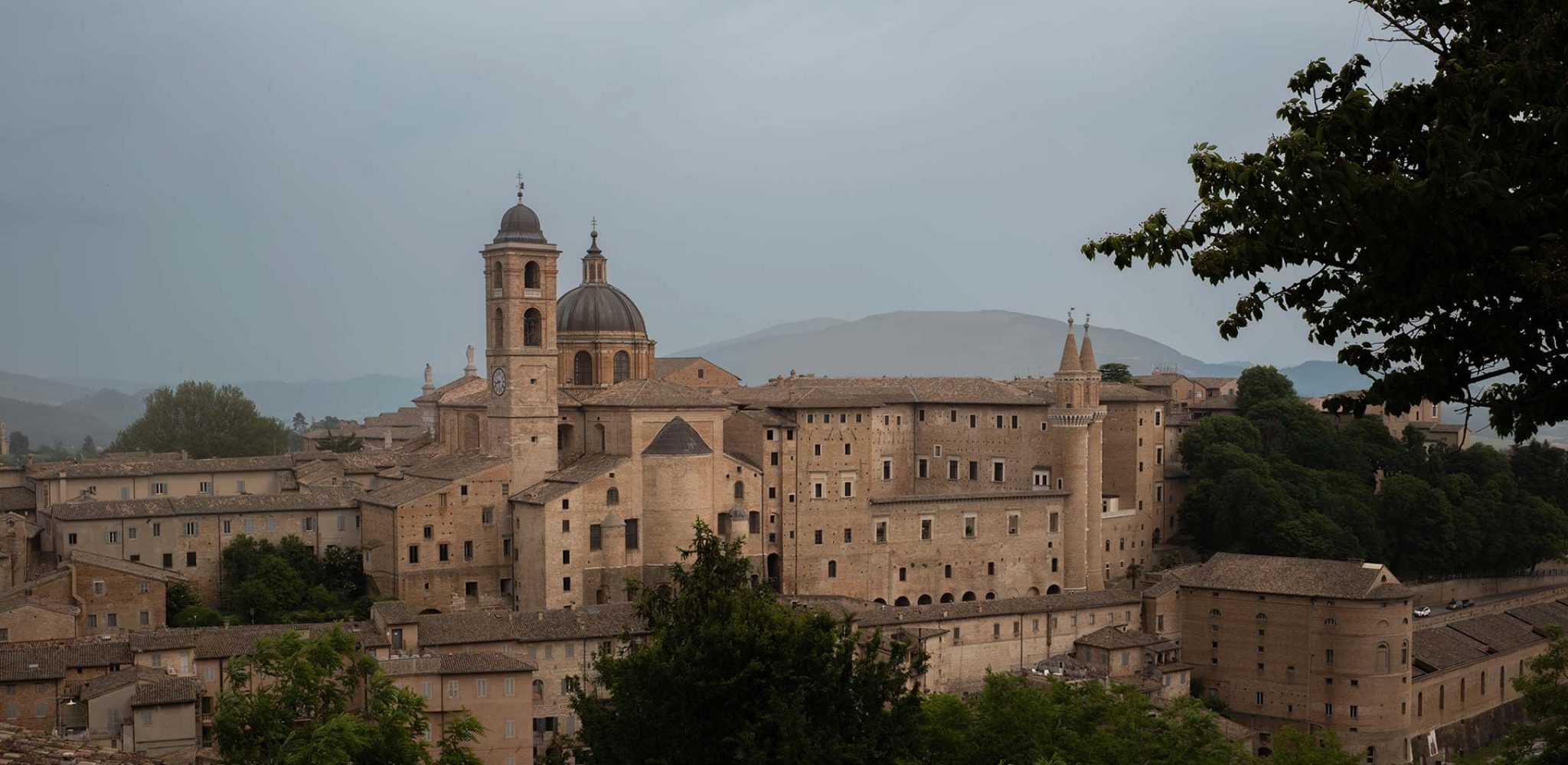 Der Palazzo Ducale von Federico Montefeltro in Urbino vor den Hügeln der Region Marken in Italien.